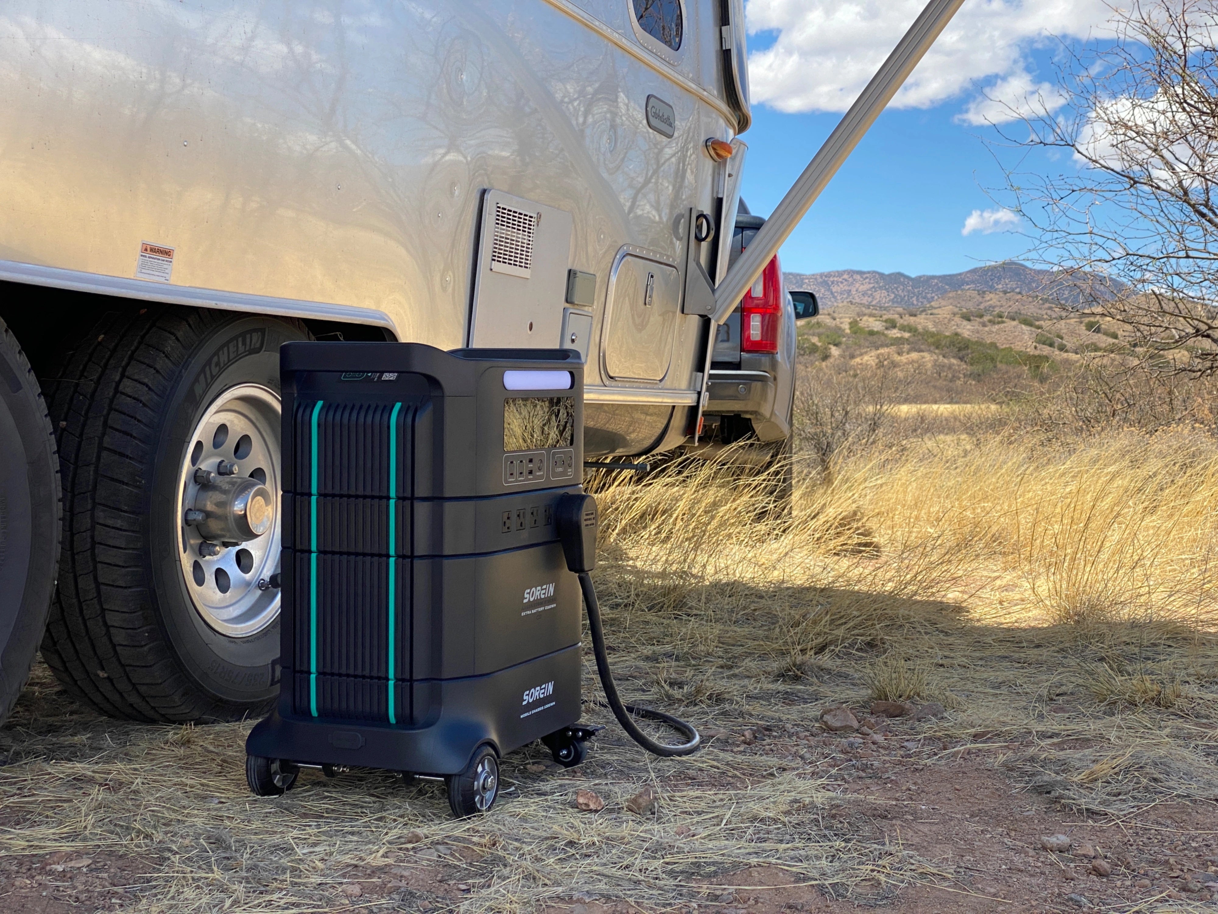 RV owner using portable power station during summer camping